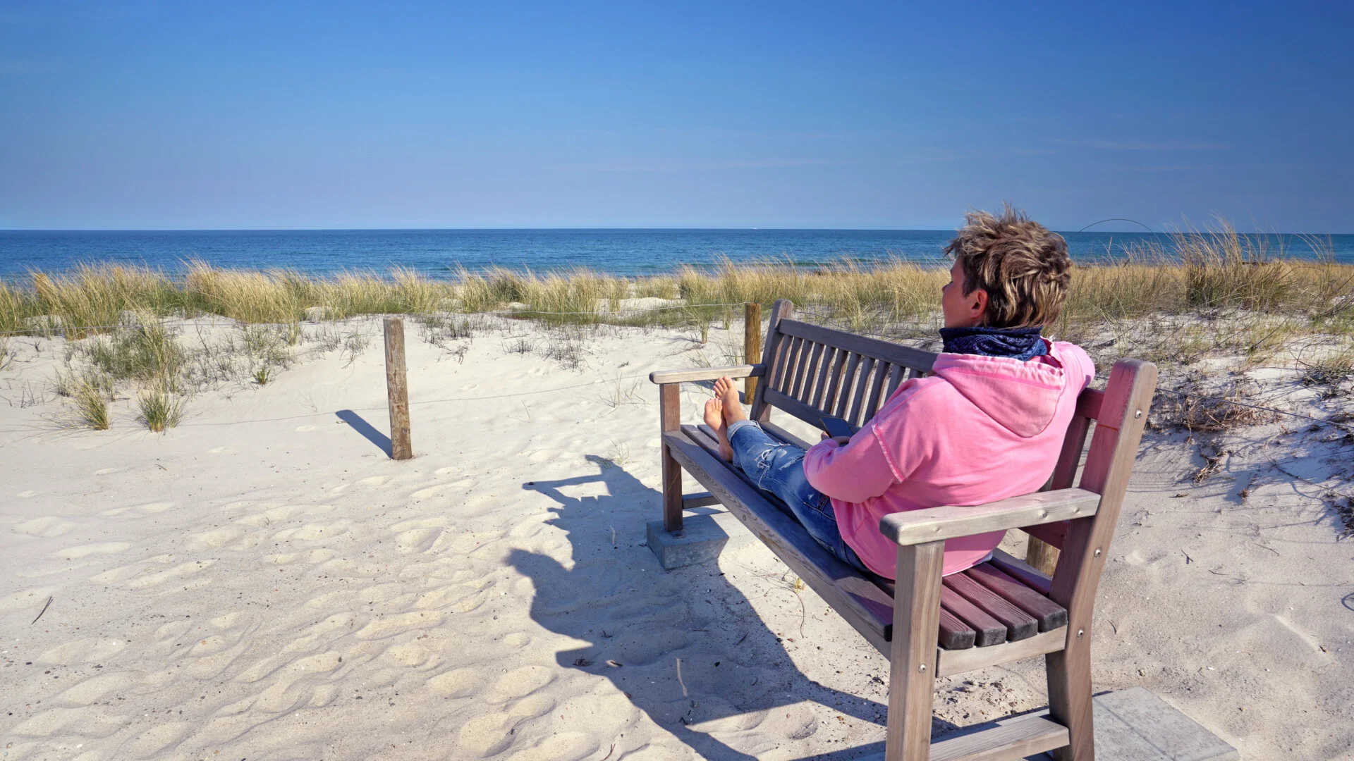 Frau auf Bank am Strand