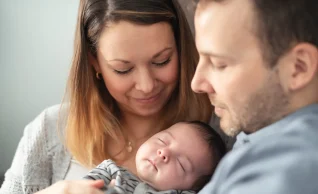 Eltern halten ihr Baby in den Armen