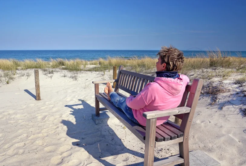 Frau auf Bank am Strand