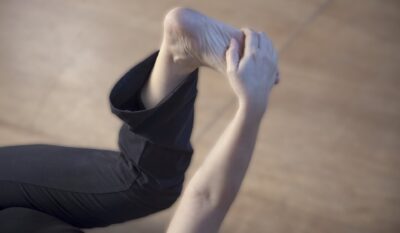 Feldenkrais: Klient*in fasst sich am Fuss