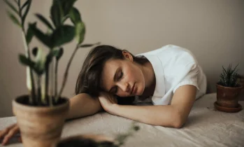 Frau legt Kopf müde auf den Tisch